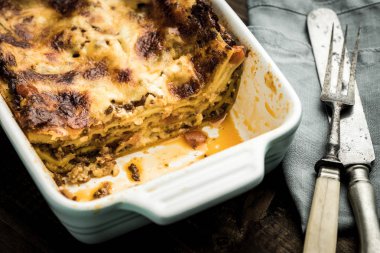 Ev yapımı lazanya Bolognese ve koyu ahşap arka plan üzerinde Mozzarella peyniri