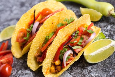 Üç renkli Meksika Tacos taş zemin üzerine kabuklarında
