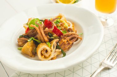 Fried Squids Tentacle, biber ve nane yaprakları üzerinde beyaz Pla