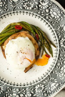 Haşlanmış yumurta, yeşil kuşkonmaz ve pul biber ile ekmek. Sağlıklı kahvaltı konsepti.