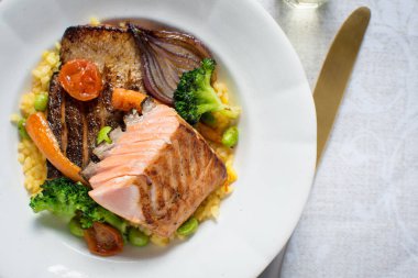 Beyaz tabakta sebzeli ızgara somon fileto