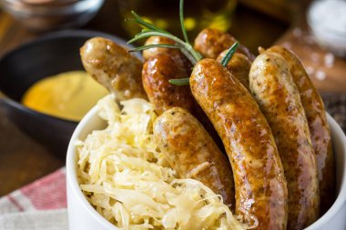 Geleneksel Alman sosisleri lahana salatası, hardal ve bira ile