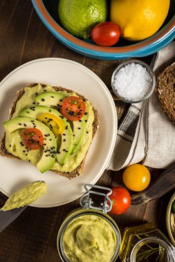 Avokado yaymak ve kiraz domates ve siyah susam ile üzerinde dilim