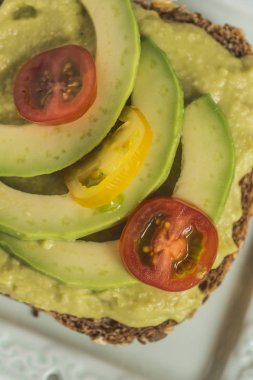 Yeşil avokado yayılması ve organik dilimleri taze kiraz domates ile