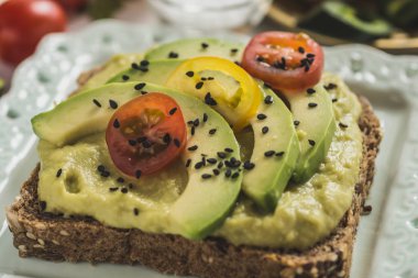 Yeşil avokado yayılması ve organik dilimleri taze kiraz domates ile