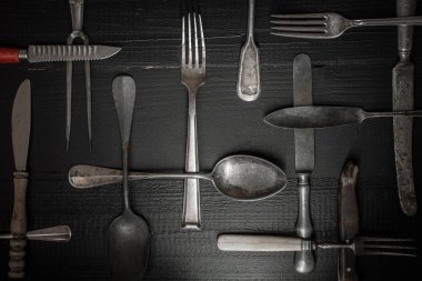 Eski koyu ahşap arka plan üzerinde rustik çatal bıçak takımı. Gümüş ve Foo