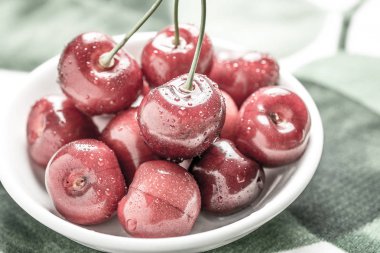 Beyaz kase su tarafından sıçrayan taze kırmızı kiraz