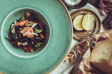 Mürekkep balığı somon ve sebze yeşil plaka üzerinde siyah spagetti mürekkep