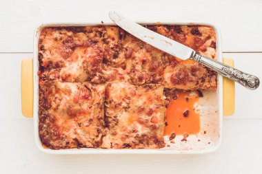 İtalyan lazanya Bolognese rustik beyaz ahşap masa üzerinde bıçak ile