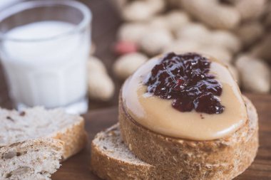 Taze fıstık ezmesi ve jöle sandviç eski rustik ahşap kesme tahtası üzerinde