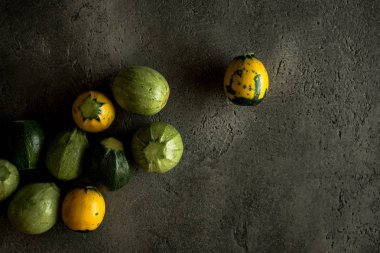 Sarı ve yeşil yuvarlak kabak rustik koyu arka plan üzerinde