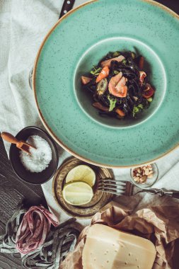 Mürekkep balığı somon ve sebze yeşil plaka üzerinde siyah spagetti mürekkep