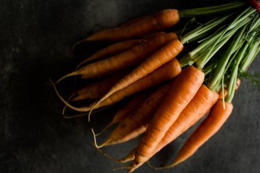 Organik Nantes havuç rustik koyu arka plan üzerinde. Temiz Superfood sağlıklı beslenme kavramı.