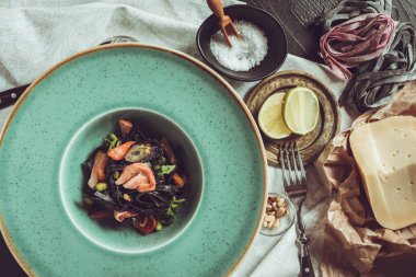 Mürekkep balığı somon ve sebze yeşil plaka üzerinde siyah spagetti mürekkep