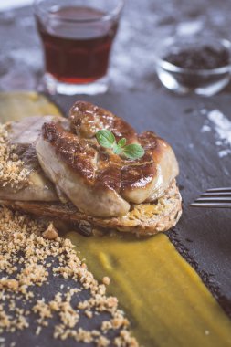 Kızarmış kaz ciğeri ile Mango püresi karanlık taş zemin üzerine. Fransız mutfağı kavramı.