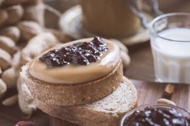Taze fıstık ezmesi ve jöle sandviç eski rustik ahşap kesme tahtası üzerinde