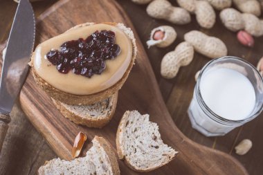 Taze fıstık ezmesi ve jöle sandviç eski rustik ahşap kesme tahtası üzerinde