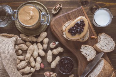 Taze fıstık ezmesi ve jöle sandviç eski rustik ahşap kesme tahtası üzerinde