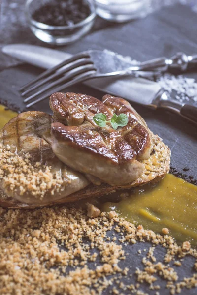 Kızarmış kaz ciğeri ile Mango püresi karanlık taş zemin üzerine. Fransız mutfağı kavramı.