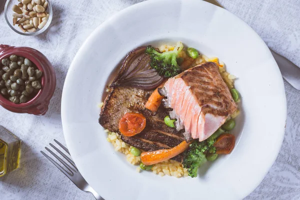 Rustik beyaz tabakta sebze ile somon fileto