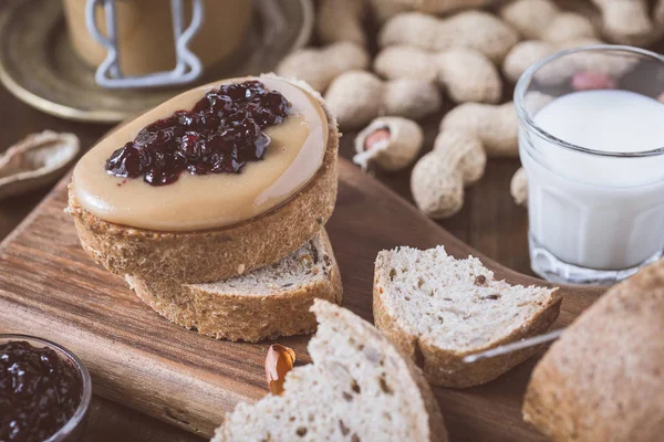 Taze fıstık ezmesi ve jöle sandviç eski rustik ahşap kesme tahtası üzerinde