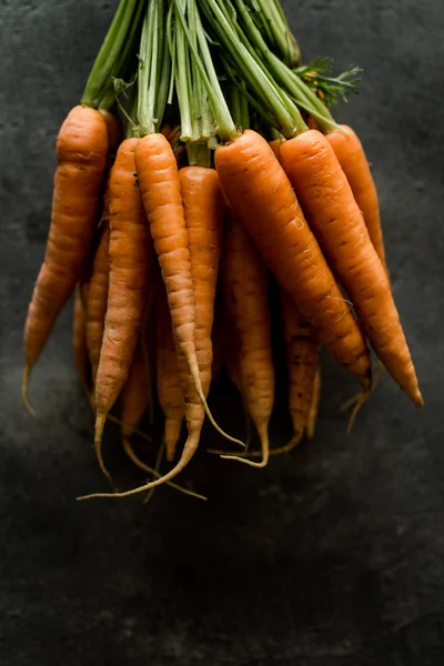 Organic Nantes Carrots on Rustic Dark Background. Fresh Superfood Healthy Eating Concept.