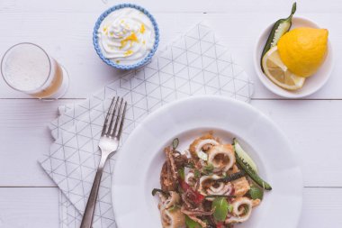 Taze kızarmış Squids kalamar, kırmızı sıcak biber biber ve yeşil nane yaprakları beyaz plaka üzerinde