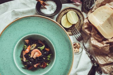 Mürekkep balığı somon ve sebze yeşil plaka üzerinde siyah spagetti mürekkep