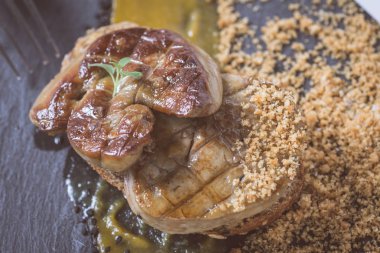 Kızarmış kaz ciğeri ile Mango püresi karanlık taş zemin üzerine. Fransız mutfağı kavramı.