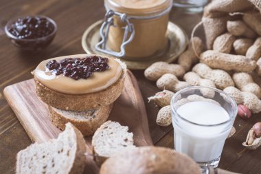 Taze fıstık ezmesi ve jöle sandviç eski rustik ahşap kesme tahtası üzerinde