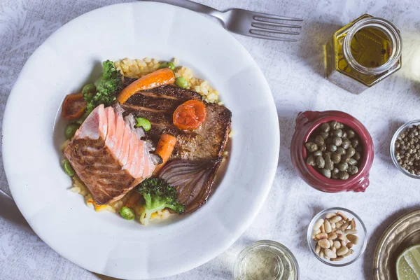 Rustik beyaz tabakta sebze ile somon fileto