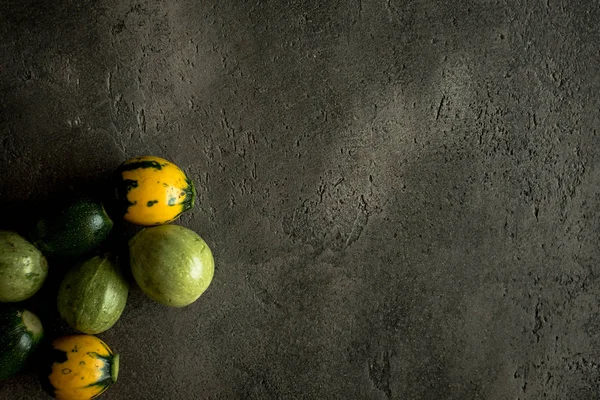 Sarı ve yeşil yuvarlak kabak rustik koyu arka plan üzerinde