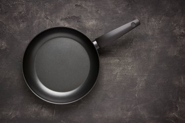 Empty Frying Pan Black on Dark Stone Surface. Culinary Backgroun clipart