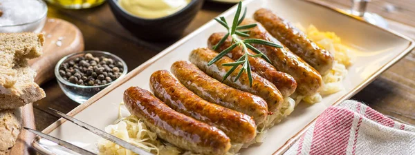 Grillwürste mit Kohlsalat, Senf und Bier. Bratwurst und Sauerkraut. — Stockfoto