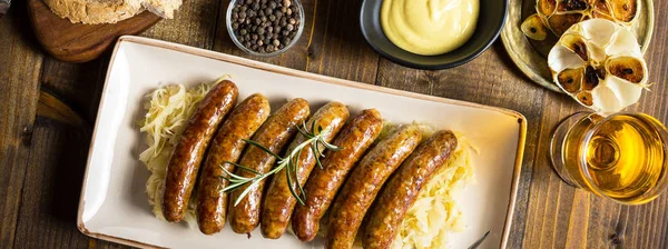 Grillad korv med kålsallad, senap och öl. Bratwurst och Sauerkraut. — Stockfoto