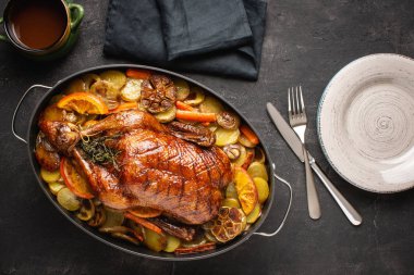 Rustik Koyu Taş Arka Plan Patates, Havuç ve Portakal ile Kavrulmuş Bütün Ördek