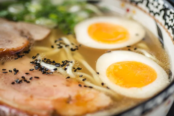 Sopa de ramen japonês com macarrão Udon, carne de porco, ovos e cebolinha no fundo de pedra escura — Fotografia de Stock