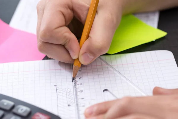 Руки школяра з малюнком лінійки на папері. Математична концепція — стокове фото