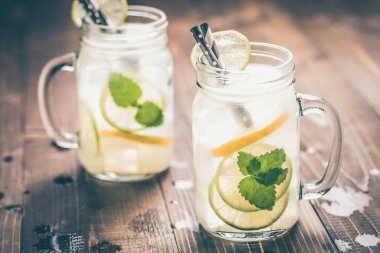 Soğuk Taze Mojito Kokteyl Limonata Buz ile, Limon ve Nane Yaprakları Mason Kavanoz Rustik Koyu Ahşap Arka Plan üzerinde. Yaz Konsepti.