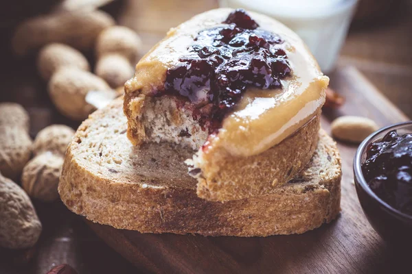 Mantequilla de cacahuete y jalea en la tabla de cortar madera rústica. Desayuno saludable casero . — Foto de Stock