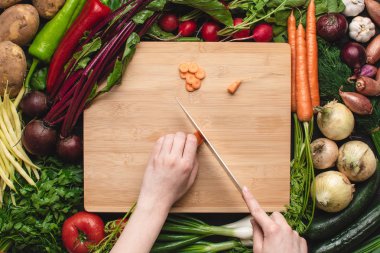 Şef bıçak ile kadın eller ahşap tahta üzerinde havuç kesme