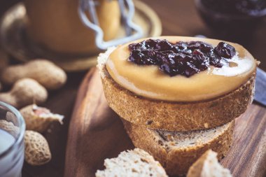 Fıstık ezmesi ve Jelly rustik ahşap kesme tahtası üzerinde. Ev yapımı sağlıklı kahvaltı.