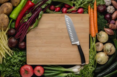 Ahşap kesme tahtası üzerinde taze sebzeler ile mutfak Santoku bıçak. Vejetaryen ham gıda. Sağlıklı yeme konsepti.
