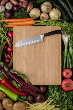 Mutfak Santoku bıçak ahşap kesme kurulu taze sebzeler ile. Vegan ham gıda. Sağlıklı yeme konsepti.