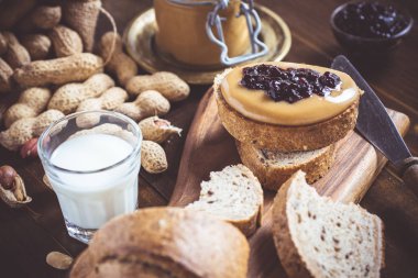 Fıstık ezmesi ve Jelly rustik ahşap kesme tahtası üzerinde. Ev yapımı sağlıklı kahvaltı.