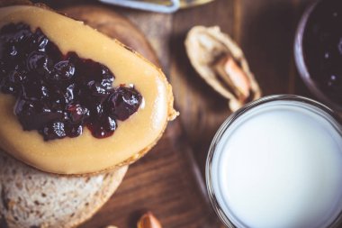 Fıstık ezmesi ve Jelly rustik ahşap kesme tahtası üzerinde. Ev yapımı sağlıklı kahvaltı.