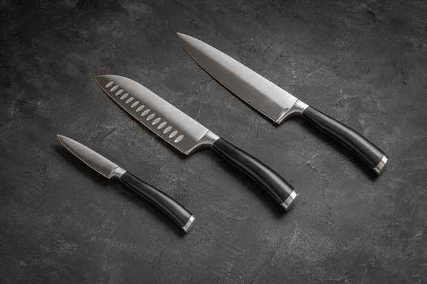 Комплект кухонных ножей на каменном фоне — стоковое фото