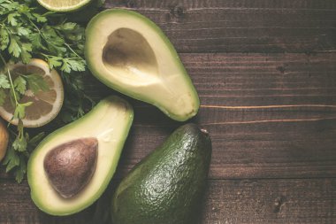 Koyu Ahşap Arka Plan Üzerinde Organik Avokado. Taze Sağlıklı Gıda Kavramı.