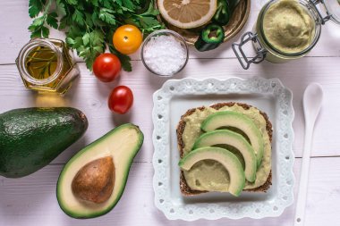 Taze Kiraz Domates ve Siyah Susam ile Organik Guacamole Avokado Spread ve Dilimler. Sağlıklı Diyet Kahvaltı Konsepti.