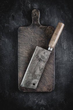 Koyu Arka Plan üzerinde Kasap Et Cleaver ve Rustik Ahşap Doğrama Kurulu